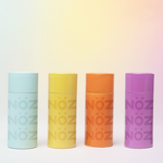 Load image into Gallery viewer, Colored variants of Nöz’s vibrant colored sunscreen against gradient background. 
