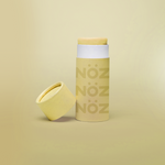 Load image into Gallery viewer, Pastel yellow colored Nözscreen bottle with removed cap against Yellow gradient background.

